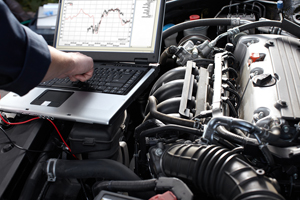 Car diagnostic with computer sitting on top of engine